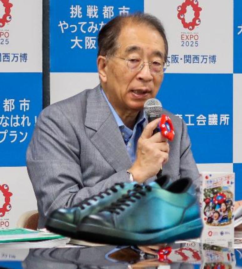 　記者会見する大阪商工会議所の鳥井信吾会頭。手前は電磁石の反発を利用した「宙に浮く靴」＝１８日午後、大阪市中央区
