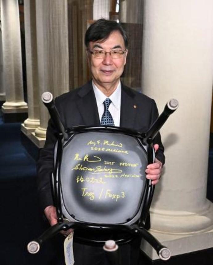 　ストックホルムのノーベル博物館を訪問し、椅子の裏に書いたサインを披露する坂口志文・大阪大特任教授＝６日（ロイター＝共同）