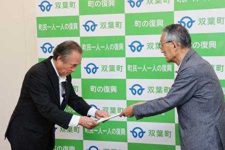 　福島県双葉町の伊沢史朗町長（左）に報告書を手渡す田中俊一委員長＝６日午前、双葉町役場