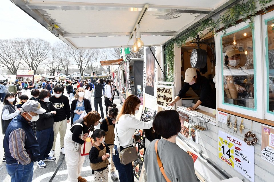 県内外のご当地グルメを販売するキッチンカーに行列を作る来場者たち＝養老郡養老町高林、養老公園