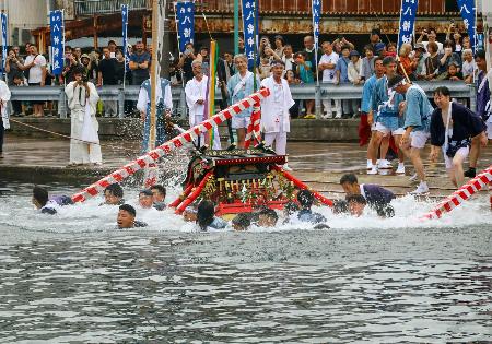　勝浦八幡神社の例大祭で行われた、男たちがみこしごと海へ入る豪快な神事＝２７日午後、和歌山県那智勝浦町