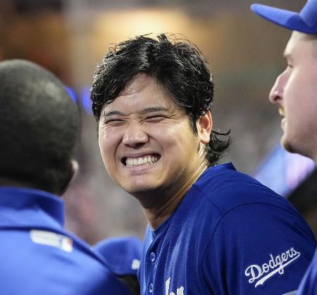 米大リーグ、ツインズ戦の９回、ベンチで笑顔を見せるドジャースの大谷翔平選手＝２４日、ミネアポリス（共同）