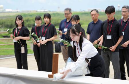 　硫黄島の天山慰霊碑で献花する弟子丸香里奈さん（手前）＝１８日午前、東京都小笠原村（代表撮影）