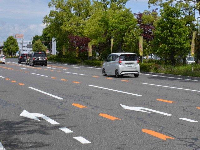 「もうすぐ進路変更禁止区間」と伝える黄色の矢羽根型路面表示がペイントされている道路＝岐阜市薮田南