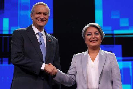 　テレビ討論会に参加し握手を交わすチリ大統領候補のハラ前労働・社会保障相（右）とカスト元下院議員＝９日、サンティアゴ（ロイター＝共同）