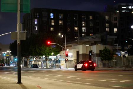　夜間外出禁止令が出た米ロサンゼルス中心部を警戒する治安当局の車両＝１０日夜（共同）