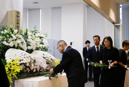 　２０２０年７月の豪雨の追悼式で献花する参列者＝５日午前、熊本県人吉市