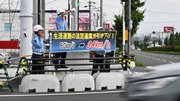 横断幕を掲げ法定速度引き下げを知らせる署員ら＝岐阜市茜部菱野、茜部中島交差点
