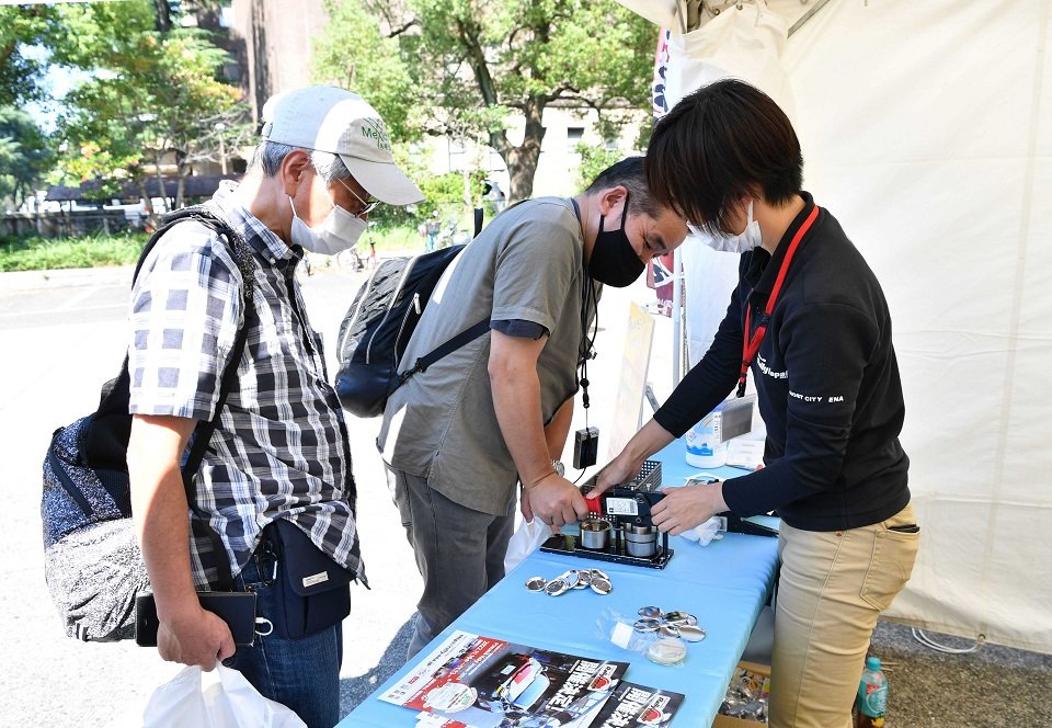 恵那市のブースでは絵柄を選んで缶バッジを作ることができ、来場者の人気を集めた＝愛知県庁