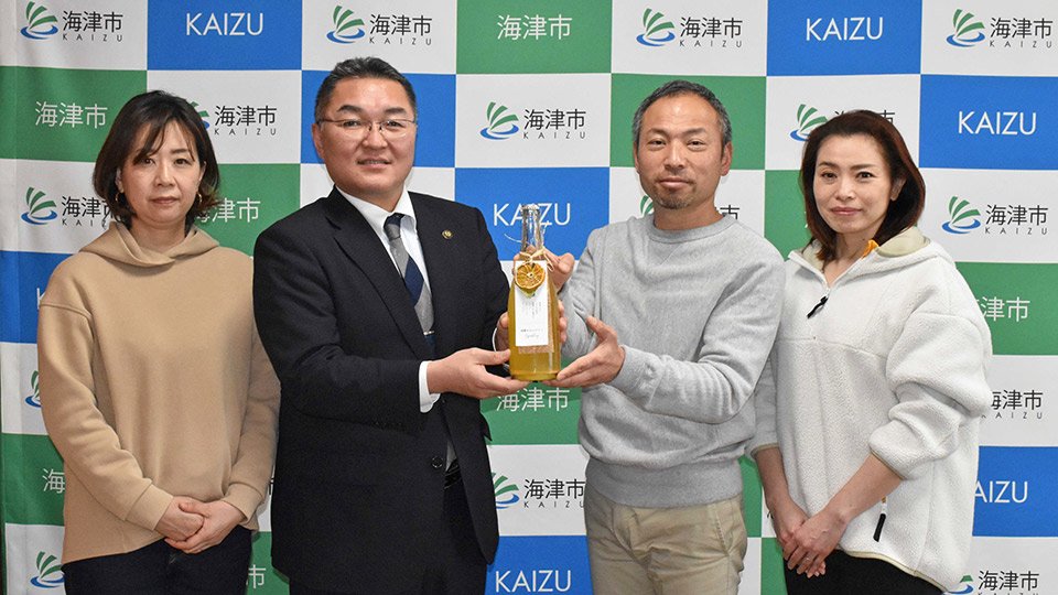 横川真澄市長に「南濃みかんワイン」を紹介する水谷酒店の水谷昌貴さん（右から２人目）ら＝海津市役所