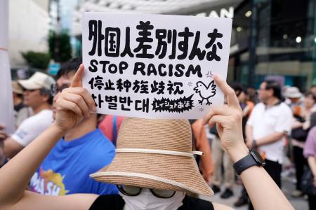 　参政党の街頭演説会場で外国人差別に抗議する人＝１９日午後、東京・銀座