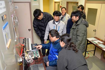 　放射線防護施設で測定した気圧を確認する研究チーム＝１４日午後、新潟県柏崎市