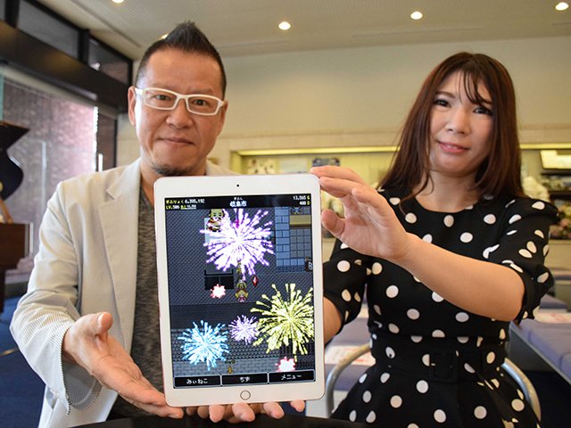 花火が打ち上がるゲーム画面を見せる和田瞳さん（右）と佐藤徳昭さん＝岐阜新聞本社