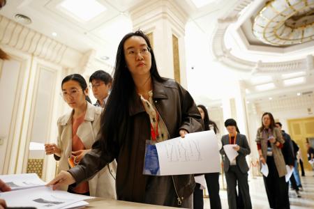 　中国国家統計局のＧＤＰ速報値に関する資料を受け取る報道関係者ら＝１６日、北京（共同）