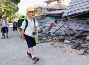 　がれきの脇を歩き、小学校の始業式に向かう児童。久しぶりの登校は楽しみだが、友達が学校にちゃんと来ているか心配しているという＝２８日午前、熊本県八代市