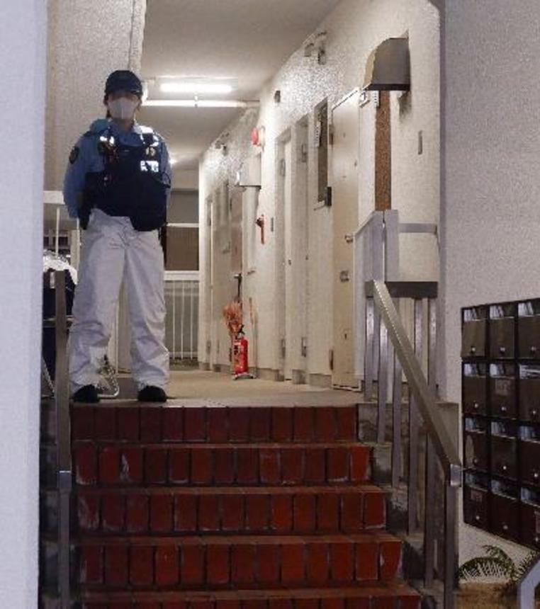 　冷凍庫に入った男性の遺体が見つかった集合住宅を警戒する警察官＝２０日午後９時２６分、神戸市中央区