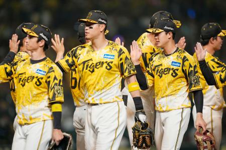 　ヤクルトに勝利し、タッチを交わす（手前右から）小幡、佐藤輝、近本ら阪神ナイン＝甲子園