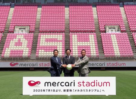　記念撮影するＪ１鹿島の小泉社長（右）ら＝１９日、カシマスタジアム