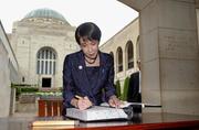 　オーストラリア戦争記念館で献花後、記帳する高市首相＝４日、キャンベラ（共同）