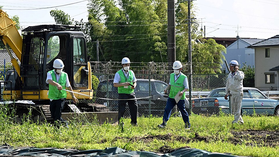 物置が飛ばされた現場を調べる気象台の職員＝２９日午後３時１７分、各務原市那加前野町