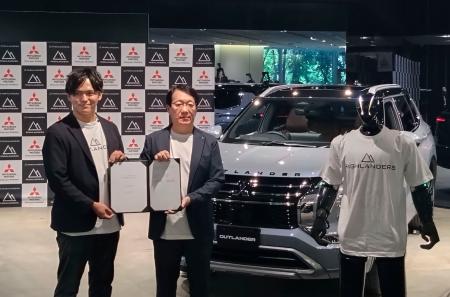 　協業を発表した三菱自動車の加藤隆雄会長兼ＣＥＯ（右）とハイランダーズの増岡宏哉ＣＥＯ。車の手前は人型ロボット＝９日午後、東京都港区