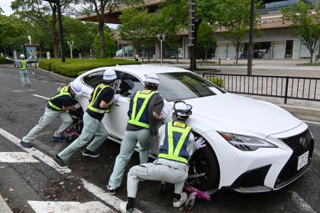 　千葉市役所周辺の道路で、放置車両を動かす市職員ら＝１５日