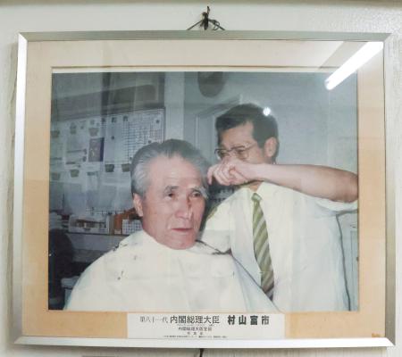 　村山富市元首相が通っていた理容室に飾られている写真＝１７日午後、大分市