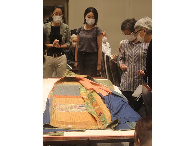 能装束を広げ解説をする山口朋子さん（左端）＝岐阜市大宮町、市歴史博物館