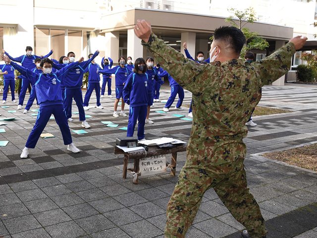 自衛隊で行われている「自衛隊体操」を体験する生徒たち＝大垣市三塚町、東中学校