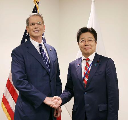 　握手する加藤財務相（右）とベセント米財務長官＝２４日、ワシントン（財務省提供）