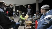 避難場となっている穴水町役場の玄関前で暖を取る避難者たち＝５日午後６時２０分、石川県鳳珠郡穴水町