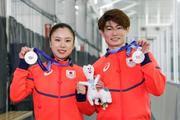 　フィギュアスケート団体で獲得した銀メダルを掲げる、アイスダンスの吉田唄菜（左）と森田真沙也＝京都府宇治市