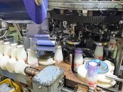 飲み口にビニールひもとフードが取り付けられる牛乳瓶＝関市観音前、関牛乳