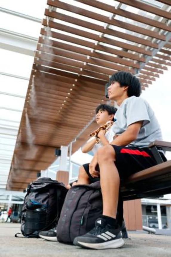 　気温が国内最高を更新する４１・８度に達した群馬県伊勢崎市でミストを浴びる人たち＝５日午後