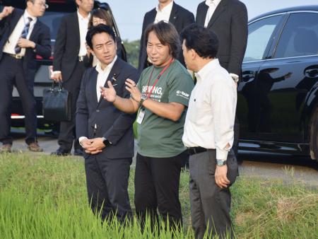 　「乾田直播」の説明を受ける小泉農相（左）＝７月、埼玉県杉戸町