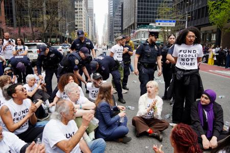 　１３日、米ニューヨーク・マンハッタンで、通りに座り込むデモ参加者ら（共同）