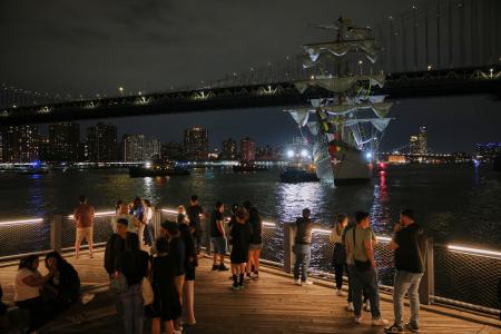 　１７日、ニューヨークのブルックリン橋に衝突したメキシコ海軍の訓練船を見る人たち（ＡＰ＝共同）