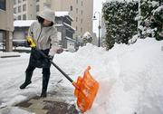 　雪かきをする人＝２３日午前、金沢市