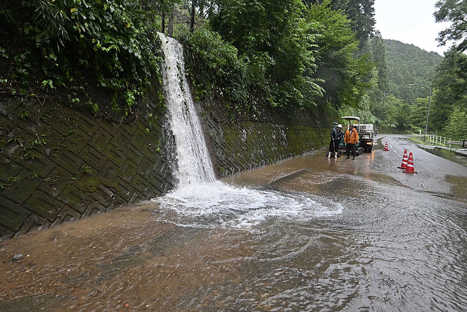 雨水が流れ込み通行に支障が出た県道＝１６日午後５時２０分、関市中之保