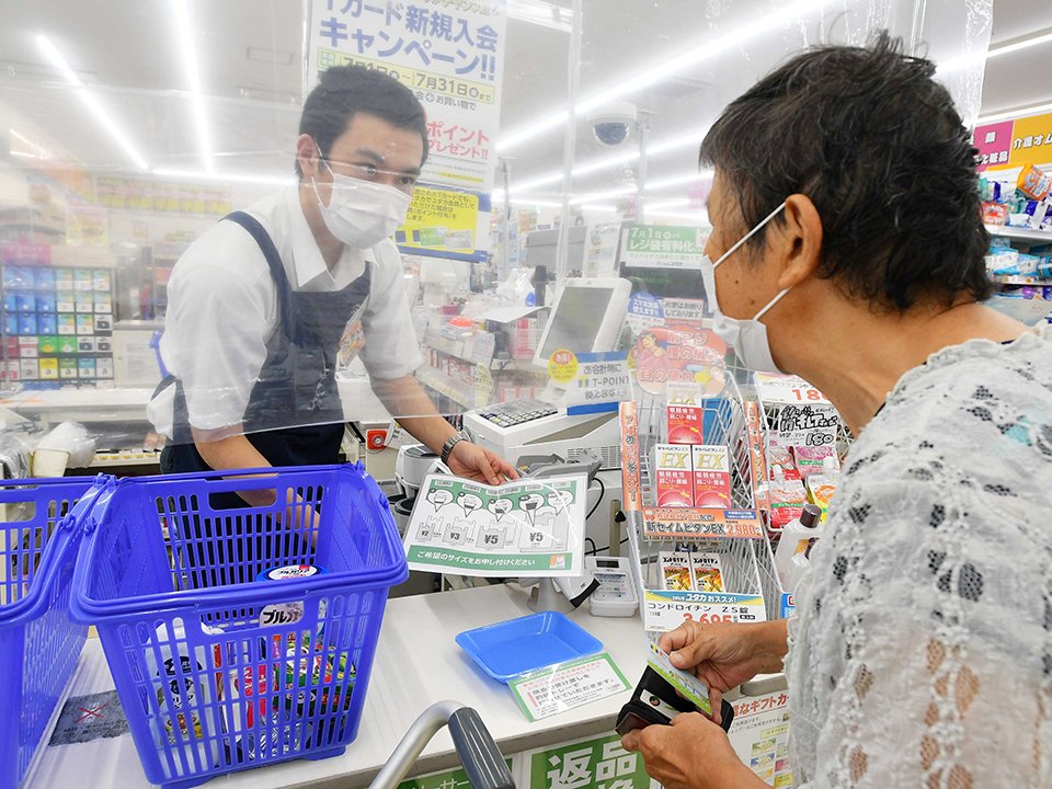 有料化したレジ袋について客に説明する店員＝１日午前１１時３０分、岐阜市福光南町、ドラッグユタカ岐阜福光南店