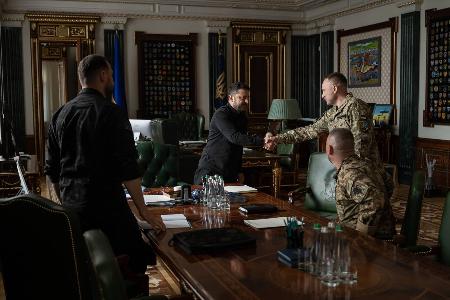 　握手するウクライナのゼレンスキー大統領（中央）とドラパティ統合軍司令官＝２０日、キーウ（大統領府提供・ＡＰ＝共同）