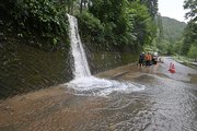 雨水が流れ込み通行に支障が出た県道＝１６日午後５時２０分、関市中之保