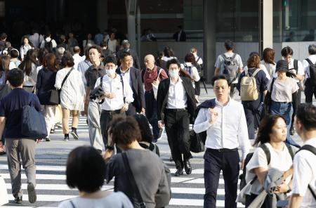 　東京・丸の内を行き交う人たち＝７月