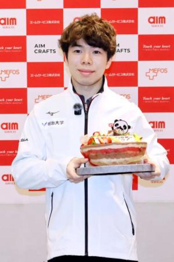 　所属先の社員交流会で贈られたケーキを手に、撮影に応じるフィギュアスケート男子の佐藤駿＝３日、東京都内