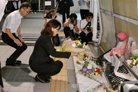 　兵庫県明石市の歩道橋事故から２４年、現場の慰霊碑に献花する丸谷聡子市長（左から２人目）＝２１日夜