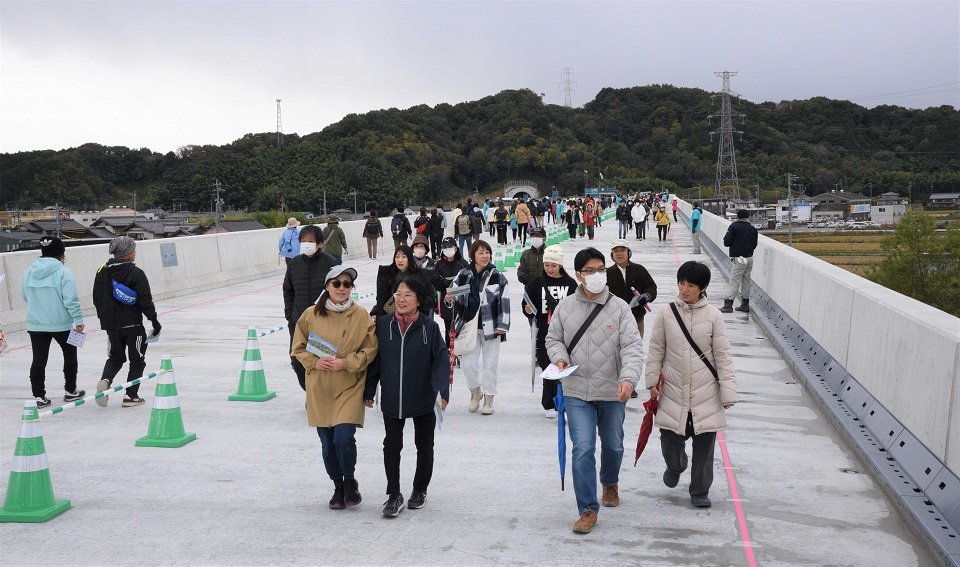 橋りょう部分が完成した東海環状自動車道の上でウオーキングを楽しむ参加者＝岐阜市中西郷