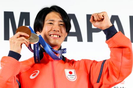 　記者会見を終え、メダルを手にポーズをとる、フリースタイルスキーの堀島行真＝１７日、イタリア・ミラノ（共同）