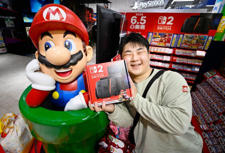 　「ニンテンドースイッチ２」を受け取り笑顔の男性＝５日午前、大阪市中央区