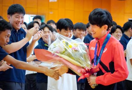 　母校を訪れ、生徒と握手するアジア大会男子マラソンで金メダルの山下一貴（右）＝７日、長崎市