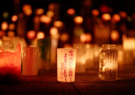 　ＪＲ双葉駅前で行われたキャンドルイベント。「あの日の記憶も未来への希望も消さない」とのメッセージが添えられていた＝１１日午後６時７分、福島県双葉町